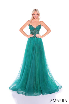 A model wears a strapless emerald green ball gown with a sparkly tulle skirt and intricate bodice.