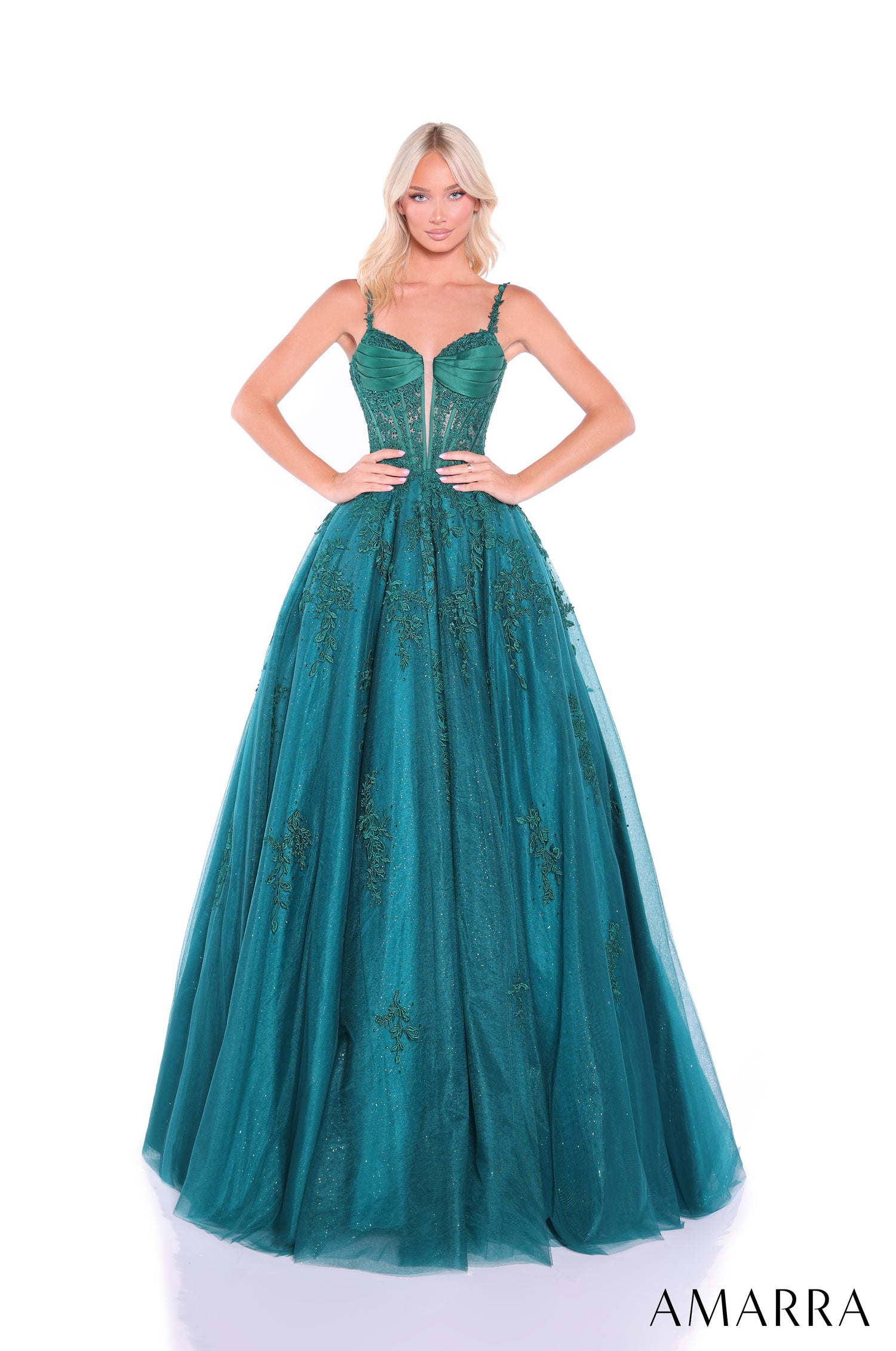 A floor-length emerald green ball gown with a corset-style bodice and embellished tulle skirt.