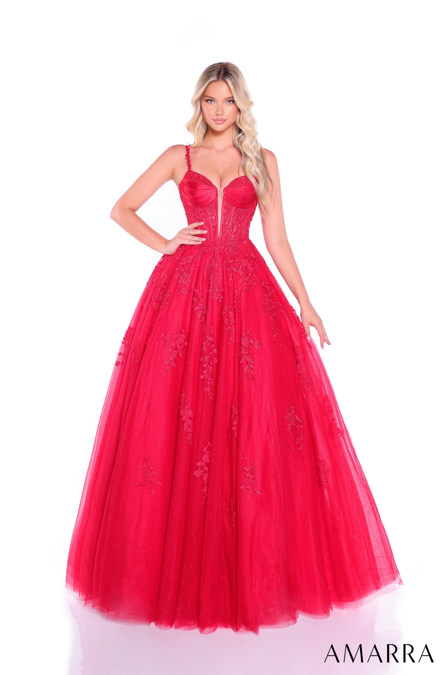 A woman wears a voluminous red ballgown with floral embroidery and a fitted corset-style bodice.
