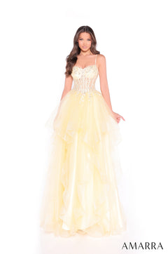 A woman wears a yellow corseted ball gown with beaded details and a flowing layered skirt.
