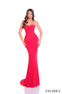 A woman stands wearing a strapless, form-fitting red evening gown with a sweetheart neckline and a long train.