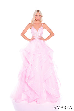 A model wears a light pink, layered ball gown with a corset-style bodice and sparkly details.