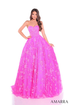 A model wears a strapless fuchsia ballgown with floral embellishments and a sweetheart neckline.