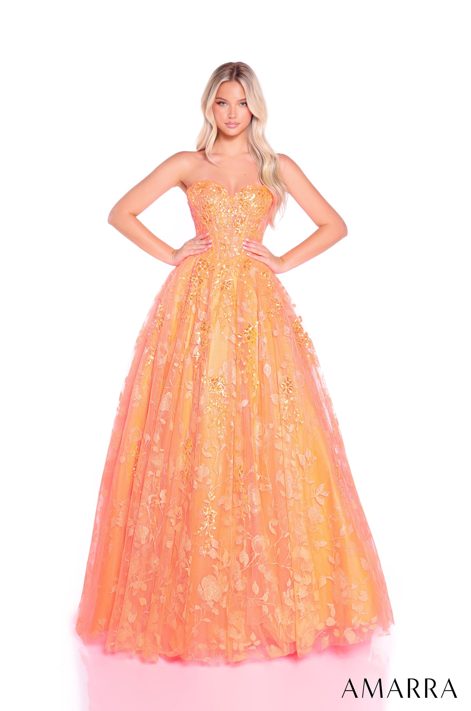 A model wears a strapless, full-length Neon Orange ballgown with shimmering floral embellishments.