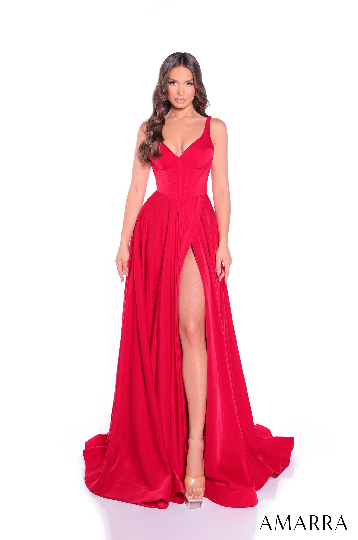A model wears a floor-length red gown with a plunging neckline, fitted bodice, and high side slit.