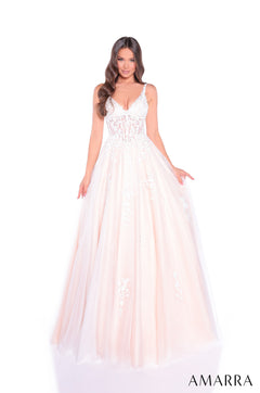 A model wears a flowing Ivory/Nude lace wedding gown with a sweetheart bodice and full tulle skirt.