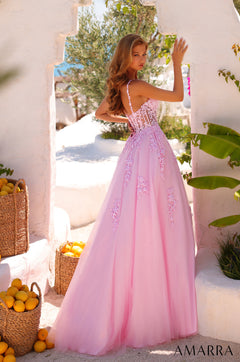 A woman in a long pink lace ball gown poses near lemon baskets in a sunlit Mediterranean-style setting.