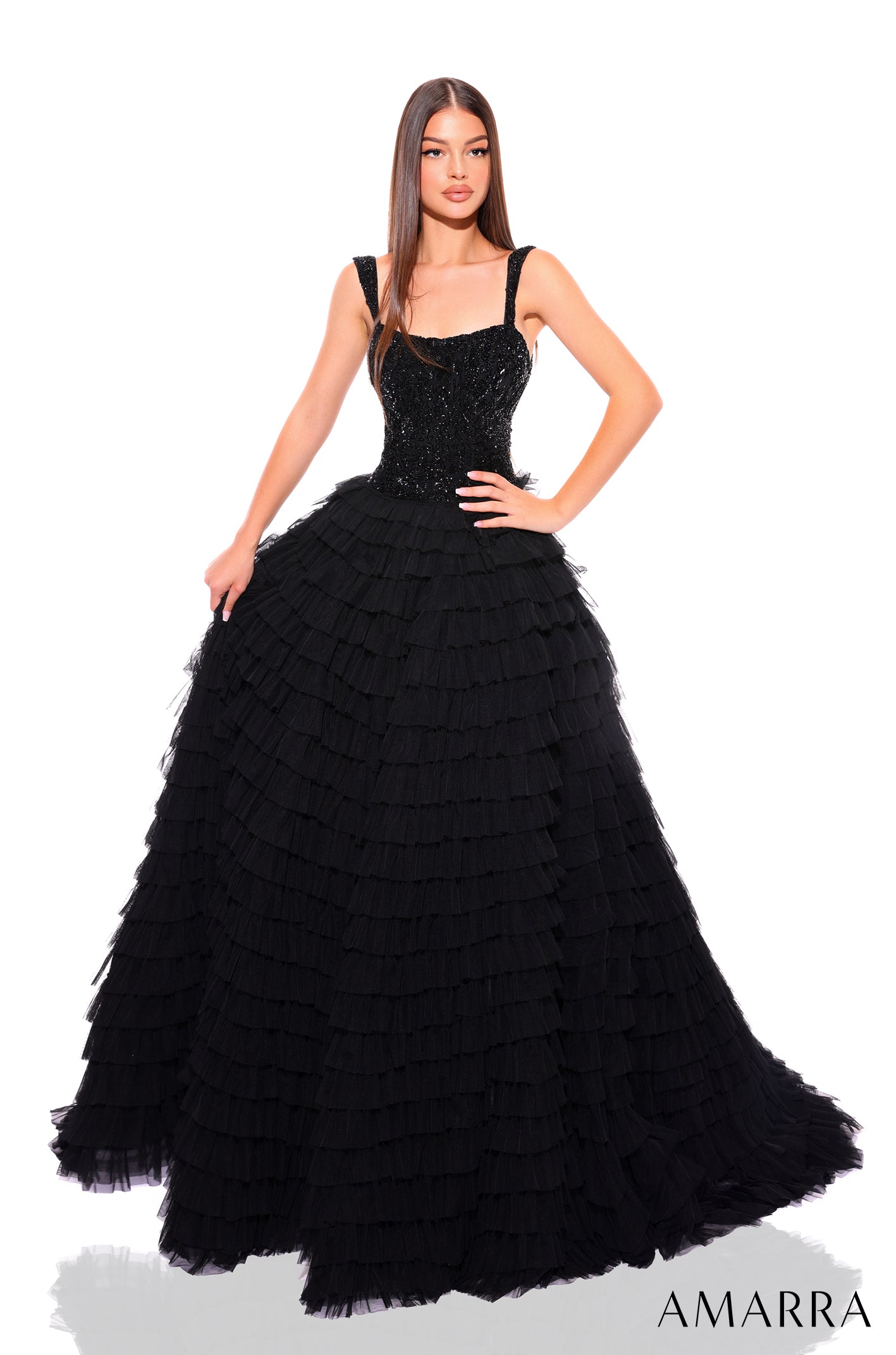 A Black ballgown with sequined bodice and layered tulle skirt, worn by a model with straight hair.