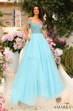 A woman wears a light blue off-shoulder ball gown with an embellished bodice in a garden setting.