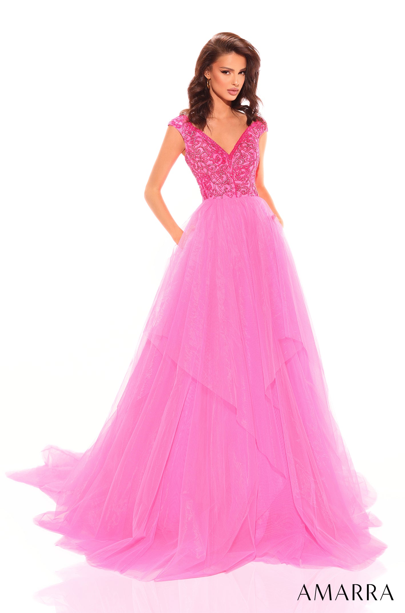 A floor-length ballgown features a beaded bodice and voluminous neon pink tulle skirt.