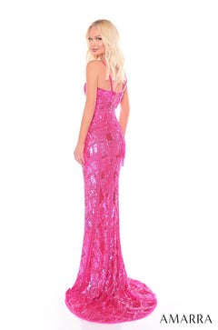 A blonde model wears a long, hot pink sequined form-fitting gown with a train at a photo shoot.