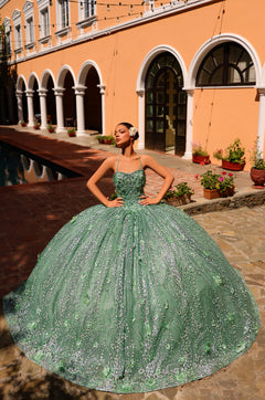 A model wears a sage green sequined ballgown with a full skirt against an orange building backdrop.