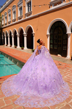 A woman in a lavender ball gown poses by a pool at an elegant Mediterranean-style building.
