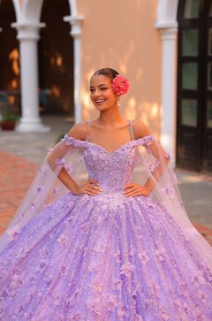 A smiling young woman wears a lavender ballgown with floral embellishments and a red flower in her hair.
