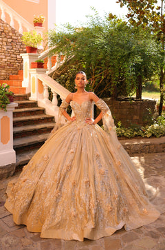 A woman wears an elaborate Gold ball gown with intricate embellishments.