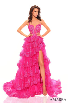 A model wears a tiered, fuchsia sequin gown with a high slit and plunging neckline by Amarra.