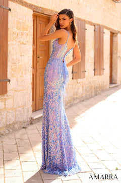 A person wears a long, iridescent blue and purple sequined gown, posing beside a stone wall with wooden doors.