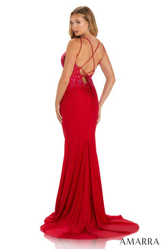 A long red mermaid-style evening gown with sparkling details and criss-cross back straps.