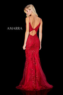 A red lace mermaid gown with a low back and train, modeled facing away on a black background.