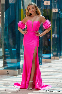 A vibrant pink strapless gown with feathered sleeves and a high slit, worn with silver heels.