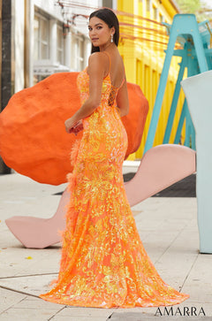 A model wears a shimmering orange and gold sequin mermaid gown with feathered details and a corset-style back.