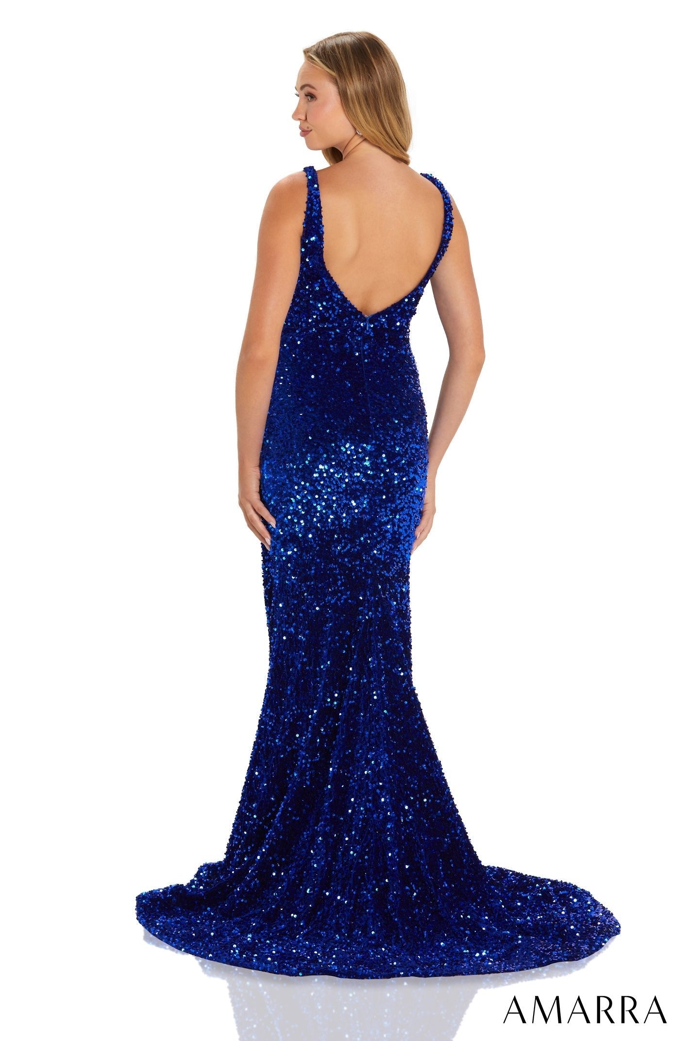 A floor-length royal blue sequin gown with a mermaid silhouette, shown from behind on a model.