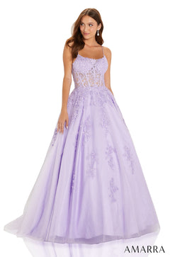 A woman wears a floor-length lilac ballgown with floral lace bodice and full tulle skirt.