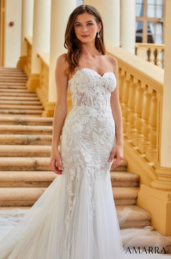 A white lace mermaid wedding gown with a sweetheart neckline, worn on a marble staircase with golden railings.
