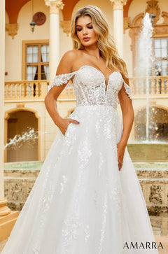 A white off-shoulder wedding gown with lace details and a full skirt.