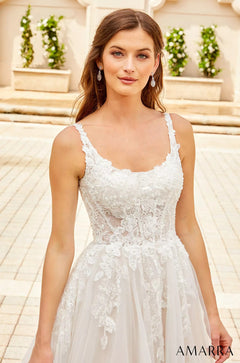 A bride wears a white lace wedding dress with a fitted bodice and flowing skirt, standing on stone steps.